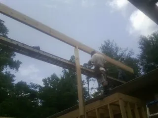 Carpenter setting a ridge beam over a new addition frame — Ice Dam Removal by Roofing Brothers in Nottawa