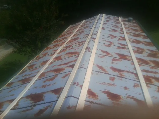 Rusted metal roof panels with new wood purlins before replacement — Storm Damage Roof Repair in Nottawa by Roofing Brothers