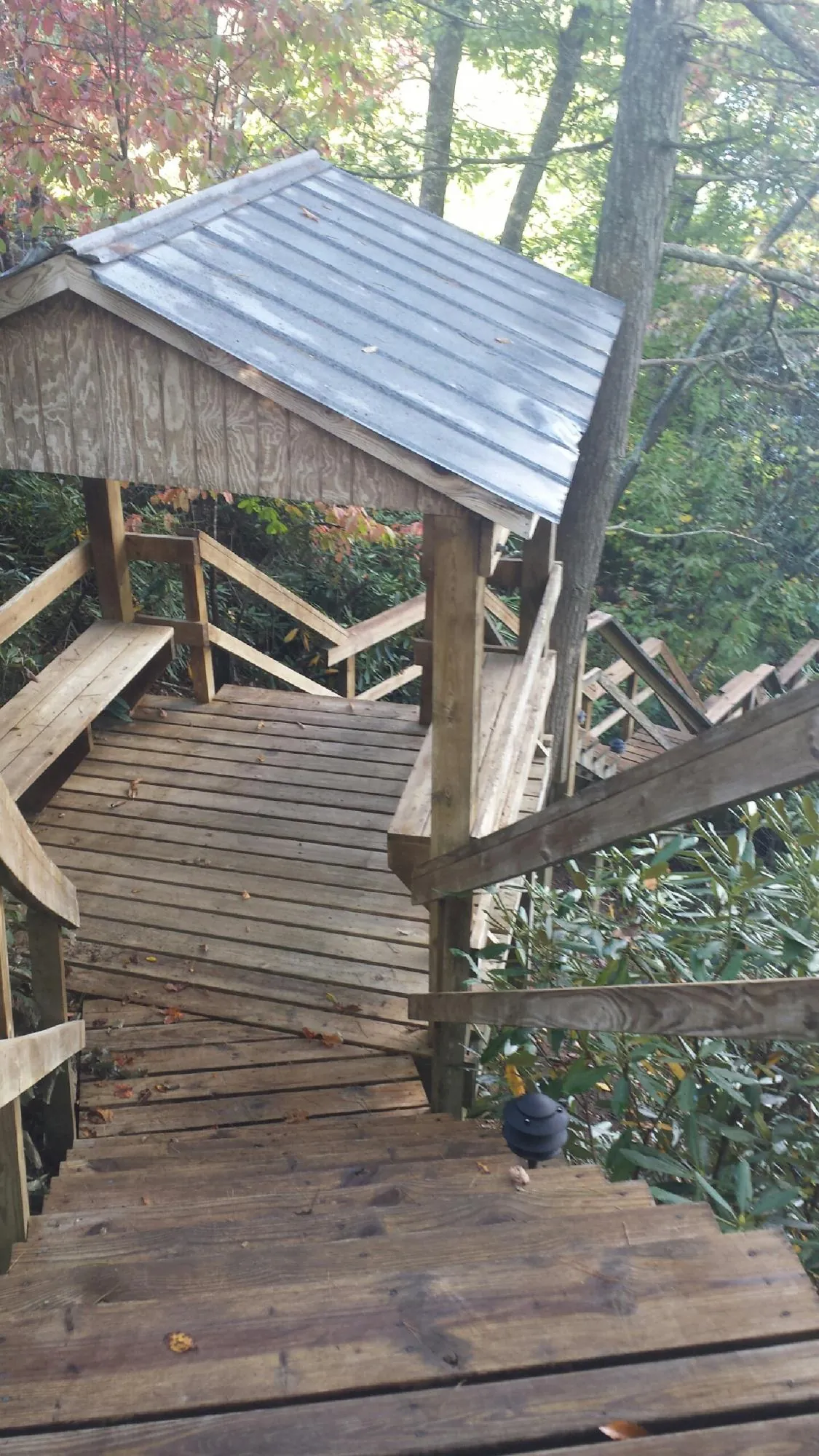 Metal roofed shelter over wooden steps on a wooded walkway — Skylight Repair & Installation work by our crew in Nottawa