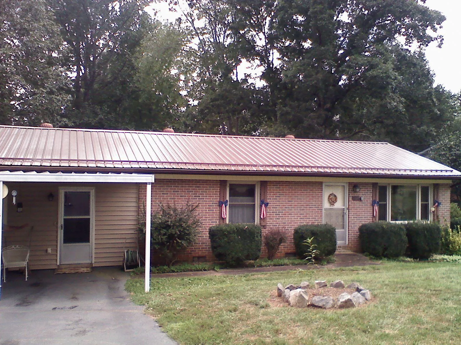 Bronze metal roof and carport on a brick ranch home — Roof Repair work by our crew in Nottawa