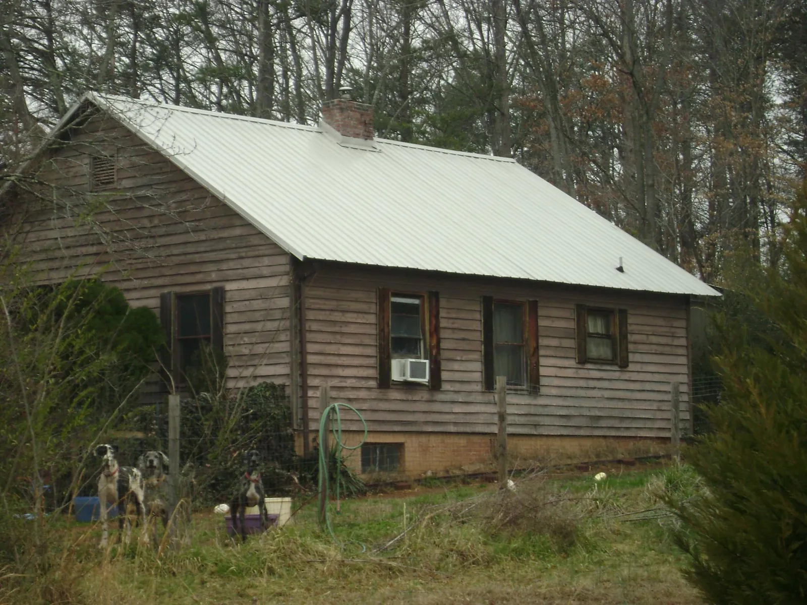 White metal roof on an old wood sided farmhouse, from a Metal Roof Installation job in Nottawa